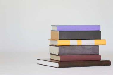 beyaz zemin üzerinde kitap yığını