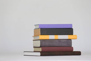 Beyaz arkaplan üzerine renkli kitap yığını