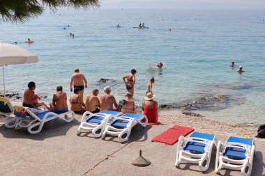 Makarska, 28.08.2023 Avrupalı turist Hırvatistan 'ın güneyindeki plajların keyfini çıkarıyor