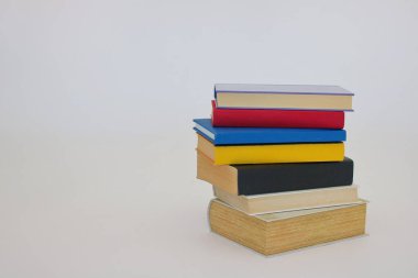 Beyaz arkaplan önünde kitap yığını