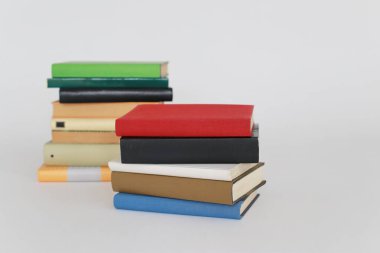 Beyaz arkaplandaki farklı kitapların yığını