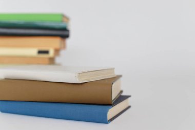 Beyaz ahşap masa üzerinde kitap yığını