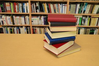 Kütüphanedeki masanın üzerinde kitap yığını