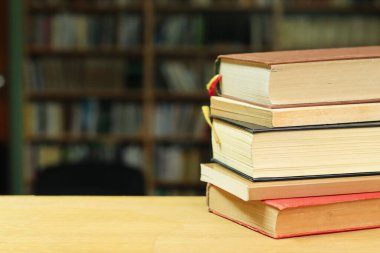 Tahta masadaki kitap yığını.