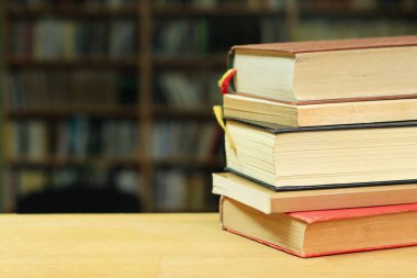 Kütüphanedeki ahşap masanın üzerinde bir yığın kitap, yazı için yer. eğitim
