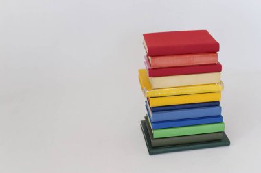 Beyaz arkaplanda izole edilmiş renkli kitapların yığını