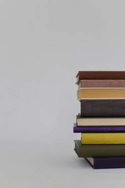 Stüdyoda beyaz arka plan üzerine bir yığın kitap.
