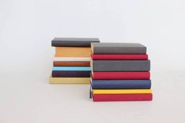 Beyaz arkaplandaki farklı kitapların yığını