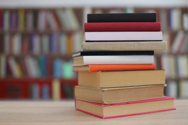 Kütüphanedeki masanın üzerinde kitap yığını