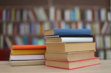 Kütüphanedeki masanın üzerinde kitap yığını