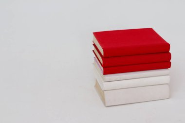 Beyaz arkaplanda bir yığın kitabın kırmızı ve siyah rengi.