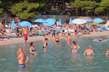 Makarska, Hırvatistan, 10.11.2023. Plaj ve insanlar yazın plajda..