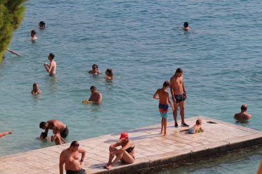 Makarska, Hırvatistan, 10.11.2023. Plaj ve insanlar yazın plajda..