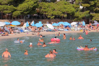 Makarska, Hırvatistan, 10.11.2023. Plaj ve insanlar yazın plajda..