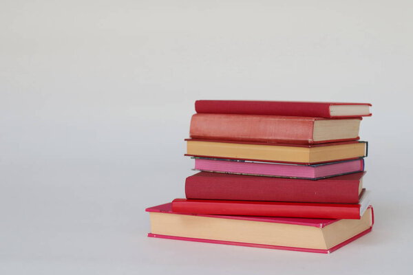 stack of books in pink background