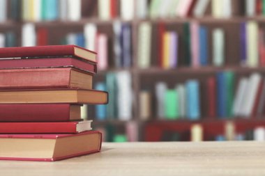 Ahşap masa, eğitim arka plan üzerinde kitap yığını