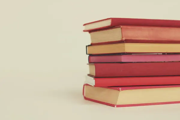 Kırmızı arkaplan üzerine kitap yığını
