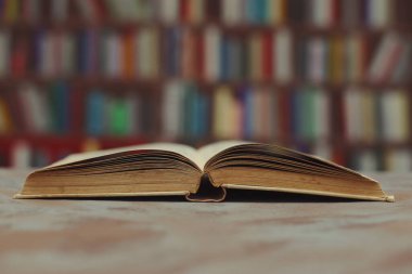 Tahta masanın üzerinde açık bir kitap, eğitim kavramı