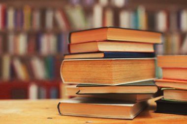 Kütüphanedeki masanın üzerinde kitap yığını