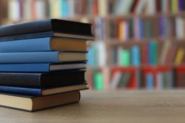 Kütüphanedeki masanın üzerinde kitap yığını