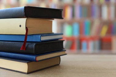 Bulanık arkaplana karşı masadaki kitap yığını
