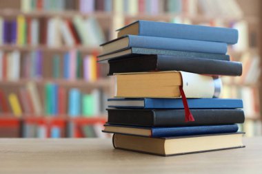 Kütüphanedeki masanın üzerinde kitap yığını