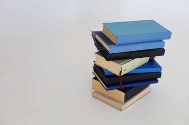 Beyaz arkaplan üzerine renkli kitap yığını.