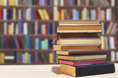 Tahta masadaki kitap yığını.