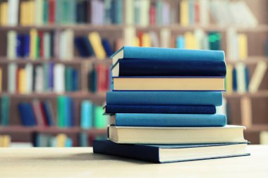 Tahta masadaki kitap yığını.