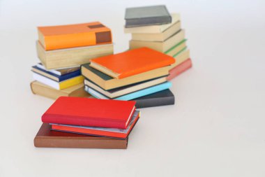 Beyaz arkaplanı olan bir yığın kitap.