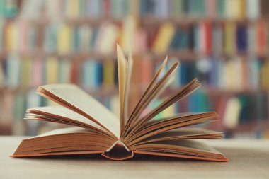 Kütüphanede ahşap masa üzerinde açık kitap