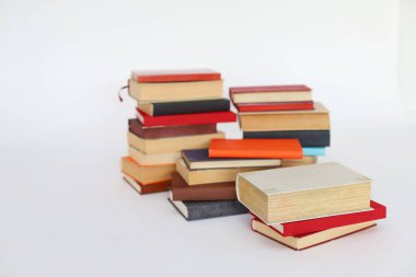 Beyaz arkaplanda izole edilmiş farklı renkli kitapların yığını