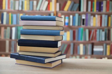 Kütüphanedeki masanın üzerinde kitap yığını