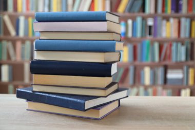 Kütüphanedeki masanın üzerinde kitap yığını
