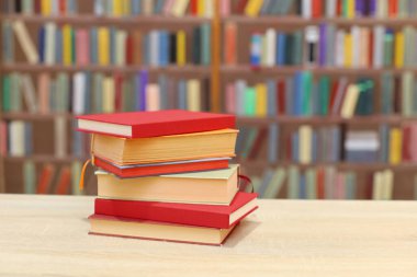 Kütüphanedeki masanın üzerinde tahta raflar olan kitaplar.