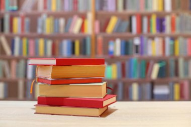 Kütüphanedeki masada renkli kitap yığını