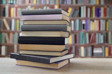 Tahta masadaki kitap yığını.