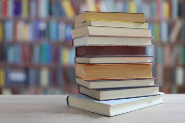 Kütüphanedeki ahşap masada yığınla kitap..