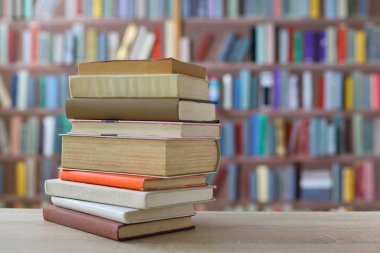 Kütüphanedeki ahşap raflarda yığınla kitap.