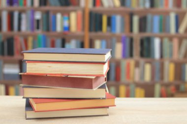 Arkaplanı bulanık olan kırmızı kaplı bir kitap yığını. Metin için yer, dünyanın en iyi yazarlarının bir dizi kitabı, edebiyat, bilim, öğrenim, tarih, eğitim için fotoğraf çizimleri