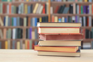 Arkaplanı bulanık olan kırmızı kaplı bir kitap yığını. Metin için yer, dünyanın en iyi yazarlarının bir dizi kitabı, edebiyat, bilim, öğrenim, tarih, eğitim için fotoğraf çizimleri