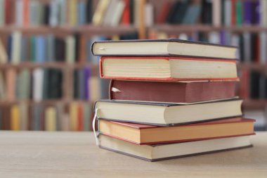 Arkaplanı bulanık olan kırmızı kaplı bir kitap yığını. Metin için yer, dünyanın en iyi yazarlarının bir dizi kitabı, edebiyat, bilim, öğrenim, tarih, eğitim için fotoğraf çizimleri