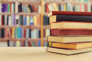 Kahve fincanı ve kitap yığını masanın üstünde.