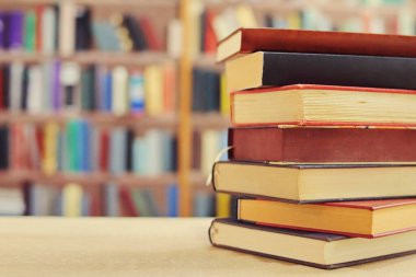 Kahve fincanı ve kitap yığını masanın üstünde.
