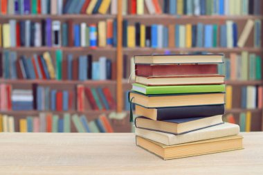 Kütüphanenin önündeki ahşap masada kitap yığını