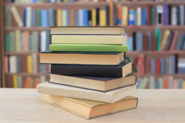 Bulanık arkaplanın önündeki ahşap masada kitaplar.