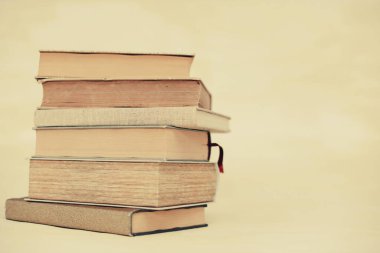 Kütüphanedeki masanın üstünde bir yığın kitap var.