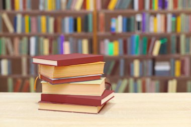 Kütüphanedeki ahşap rafta yığınla kitap.