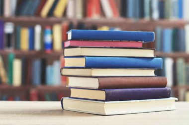 Kütüphanedeki masanın üzerinde kitap yığını