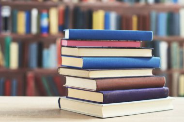 Kütüphanedeki masanın üzerinde kitap yığını